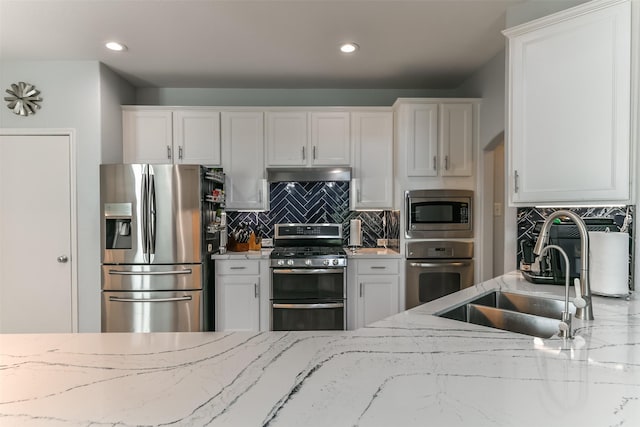 kitchen with white cabinetry, stainless steel appliances, range hood, and sink