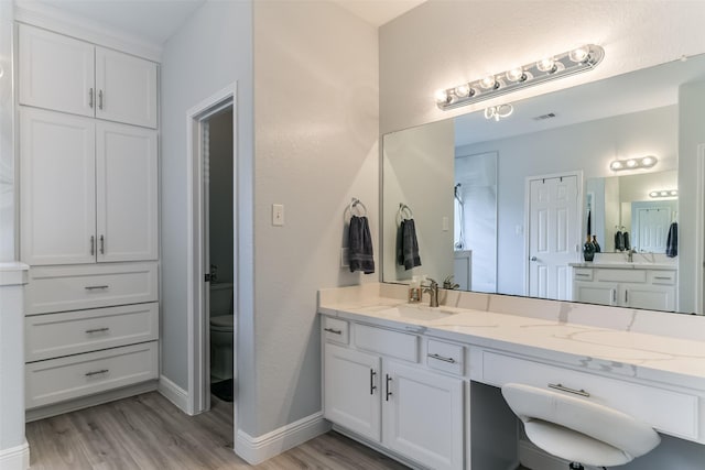 bathroom with vanity, toilet, and hardwood / wood-style floors