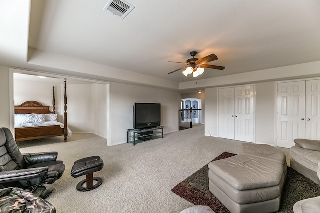 living room featuring ceiling fan and carpet