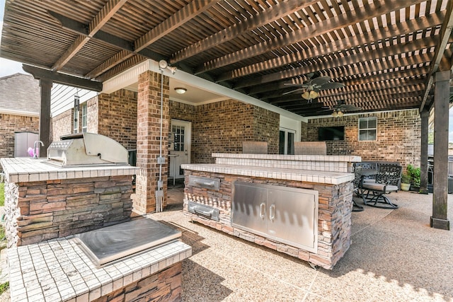 view of patio / terrace featuring an outdoor kitchen, area for grilling, ceiling fan, and a pergola