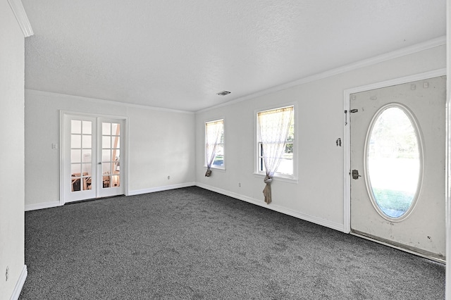 carpeted foyer entrance with ornamental molding, french doors, and a textured ceiling