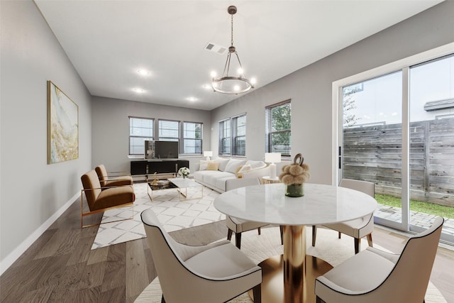 dining space with an inviting chandelier and hardwood / wood-style floors