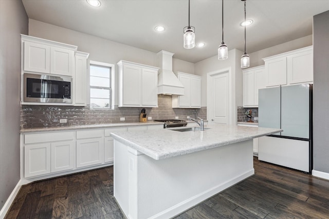 kitchen with pendant lighting, custom exhaust hood, stainless steel appliances, and white cabinets