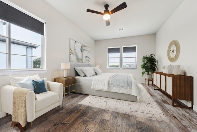 bedroom featuring dark wood-type flooring, ceiling fan, and multiple windows