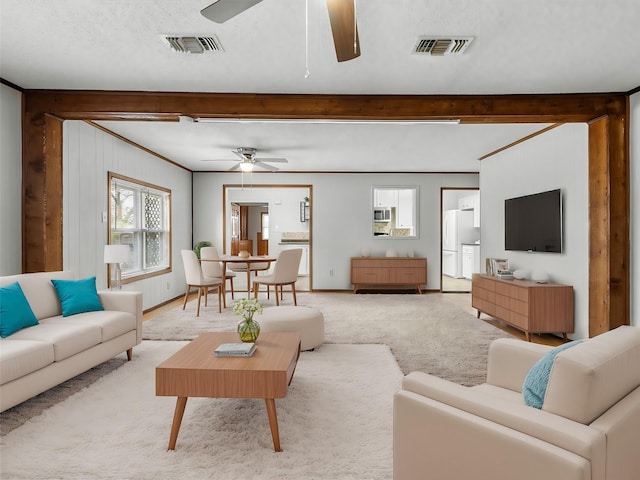 carpeted living room featuring beamed ceiling and ceiling fan