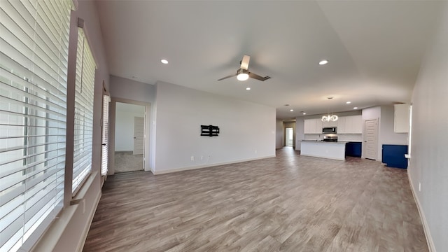 unfurnished living room featuring ceiling fan and light hardwood / wood-style floors