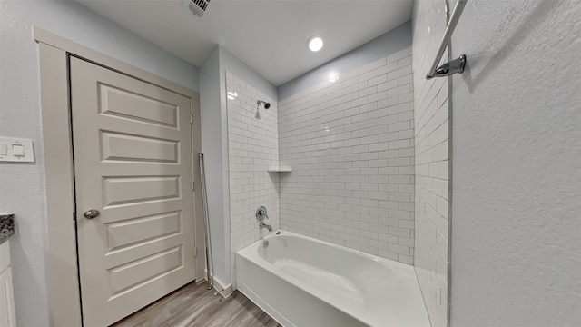 bathroom featuring tiled shower / bath and hardwood / wood-style floors