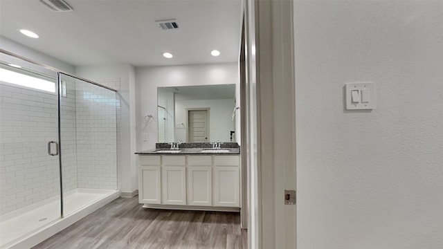 bathroom with a shower with door, wood-type flooring, and vanity