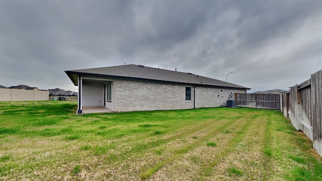 back of property featuring a patio, central AC unit, and a lawn