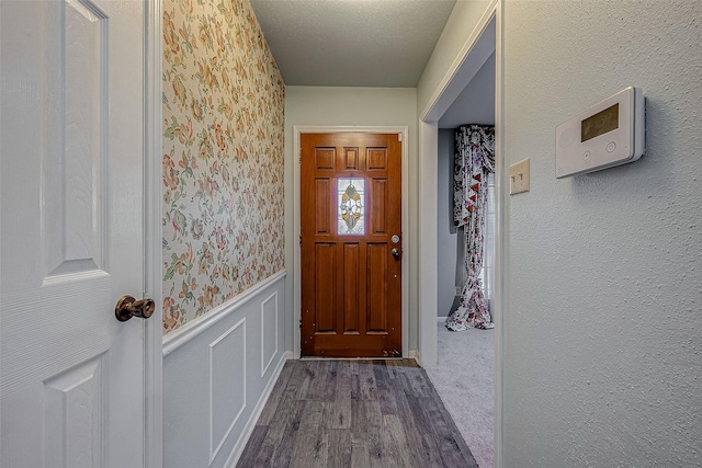 entryway with a textured ceiling and dark hardwood / wood-style flooring