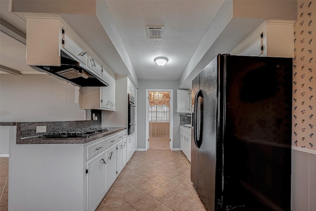 kitchen featuring extractor fan, white cabinets, light tile patterned floors, black appliances, and a textured ceiling