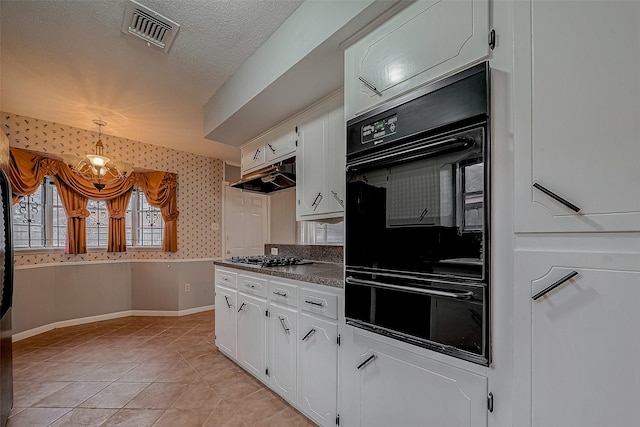 kitchen with pendant lighting, stainless steel gas stovetop, white cabinets, black double oven, and a textured ceiling