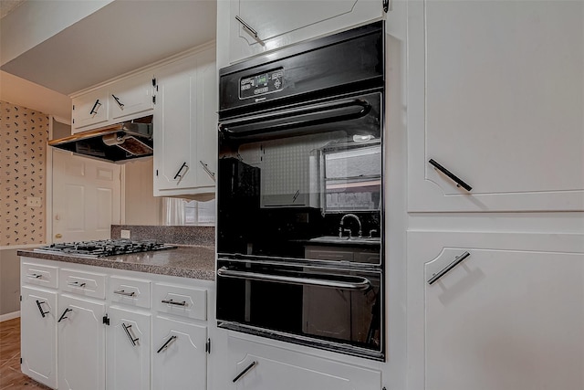 kitchen featuring white cabinetry, stainless steel gas cooktop, and double oven