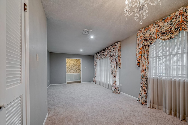 unfurnished room featuring carpet flooring and a textured ceiling