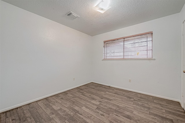 spare room with hardwood / wood-style flooring and a textured ceiling