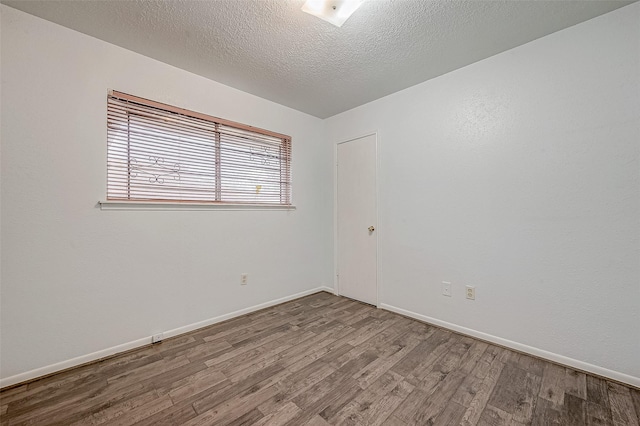 unfurnished room with hardwood / wood-style floors and a textured ceiling