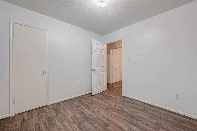 unfurnished bedroom featuring light hardwood / wood-style flooring and a textured ceiling