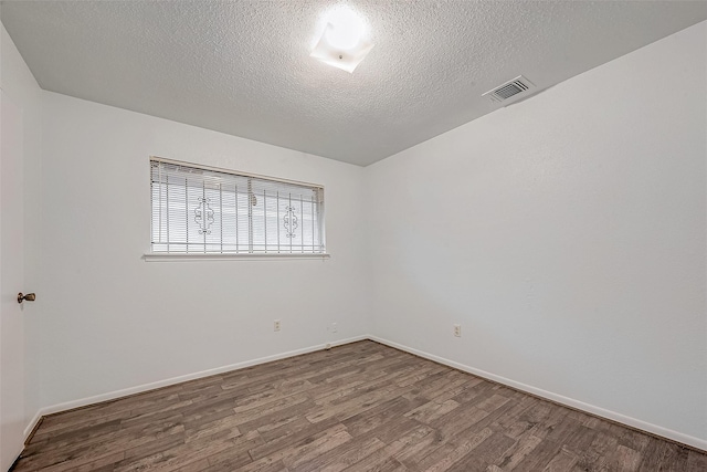 unfurnished room with hardwood / wood-style floors and a textured ceiling