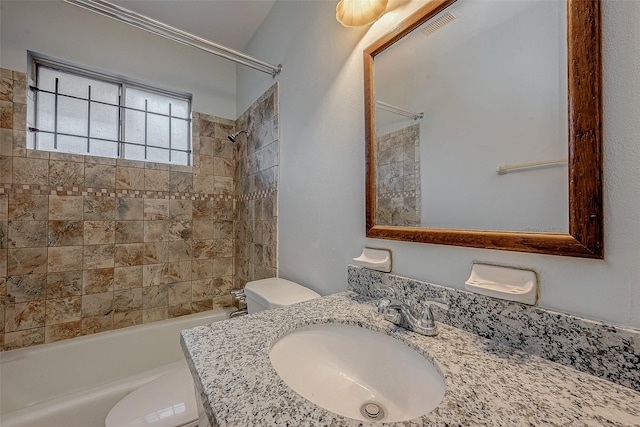 full bathroom with sink, tiled shower / bath combo, and toilet