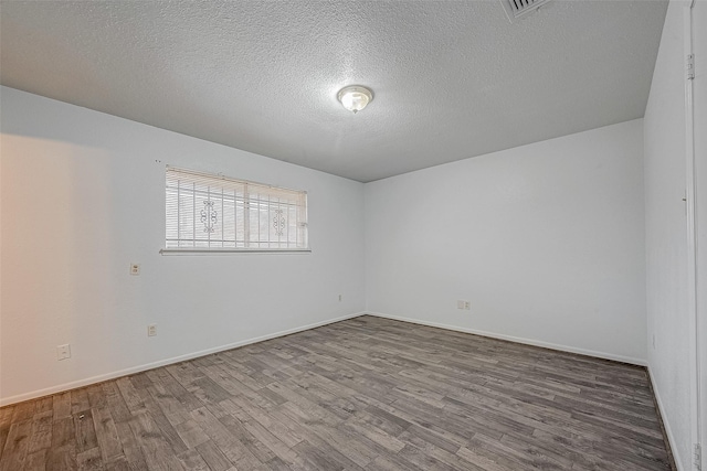 empty room with hardwood / wood-style flooring and a textured ceiling