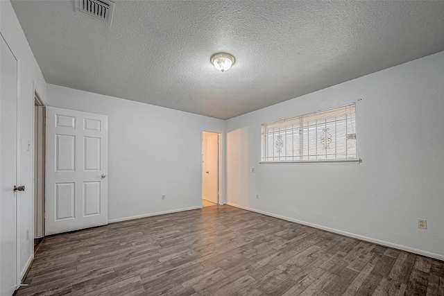 empty room featuring hardwood / wood-style floors and a textured ceiling