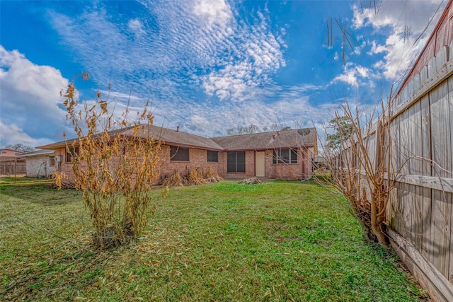 rear view of house featuring a yard