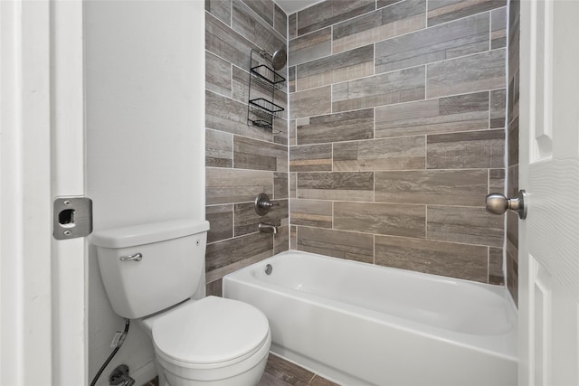 bathroom featuring tiled shower / bath combo and toilet