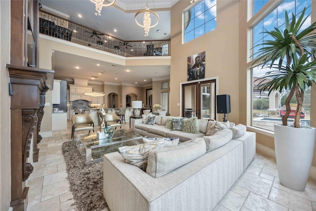 living room featuring a high ceiling, crown molding, and a chandelier