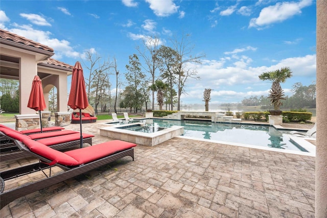 view of pool with a patio area and an in ground hot tub