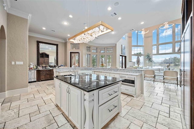 kitchen with white cabinetry, dishwasher, a kitchen island with sink, and pendant lighting