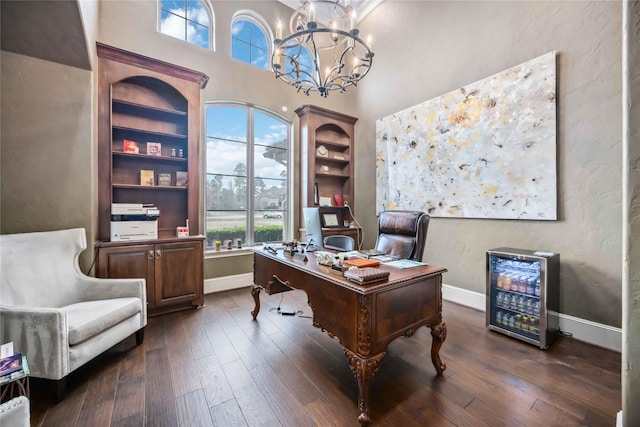 office space featuring a high ceiling, dark hardwood / wood-style floors, and an inviting chandelier