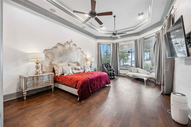 bedroom with crown molding, dark wood-type flooring, a raised ceiling, and ceiling fan