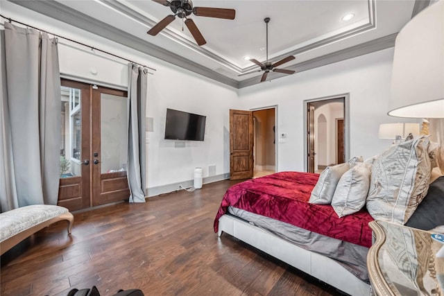 bedroom with dark hardwood / wood-style floors, ornamental molding, ceiling fan, a raised ceiling, and french doors