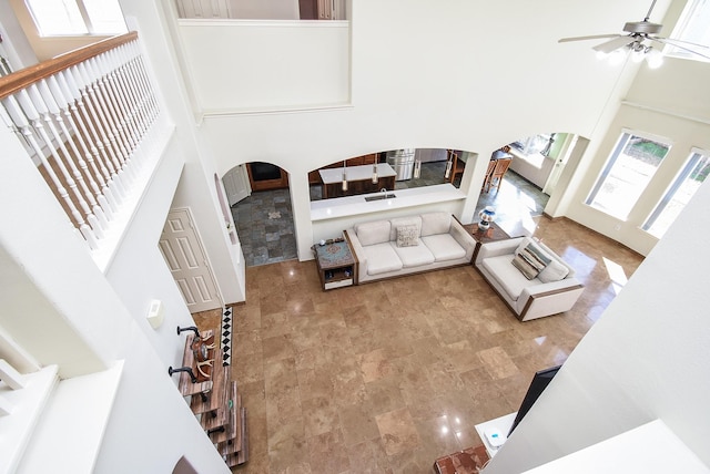 living room featuring a towering ceiling and ceiling fan