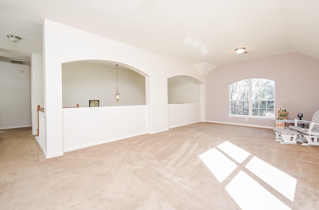 carpeted spare room with lofted ceiling