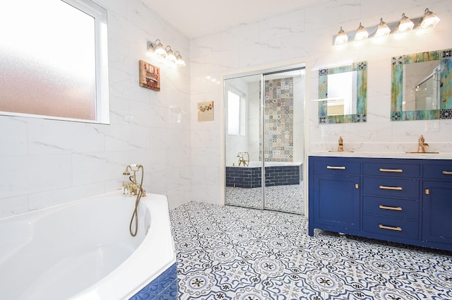 bathroom with tile walls, vanity, and separate shower and tub