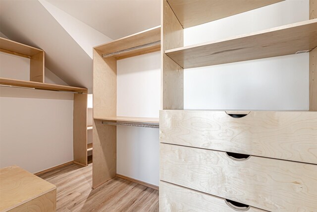 spacious closet with lofted ceiling and light hardwood / wood-style floors