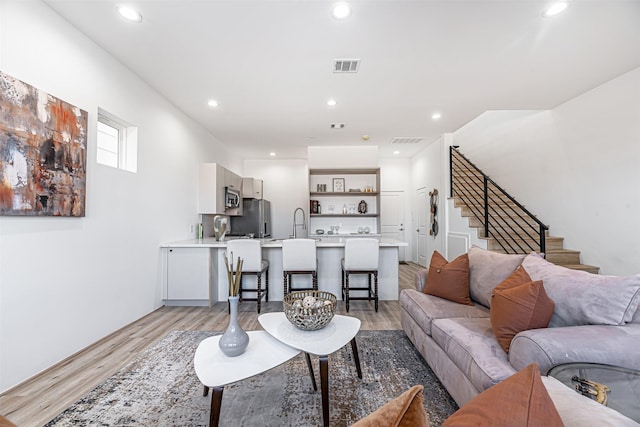 living room with sink and light wood-type flooring