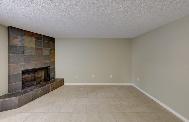 unfurnished living room featuring a tile fireplace, light tile patterned flooring, and a textured ceiling