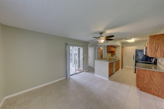 kitchen with sink, stove, stainless steel dishwasher, light stone counters, and ceiling fan