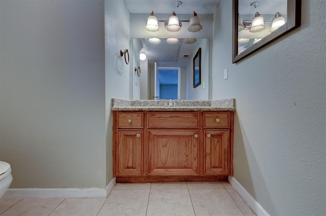 bathroom featuring tile patterned floors, vanity, and toilet