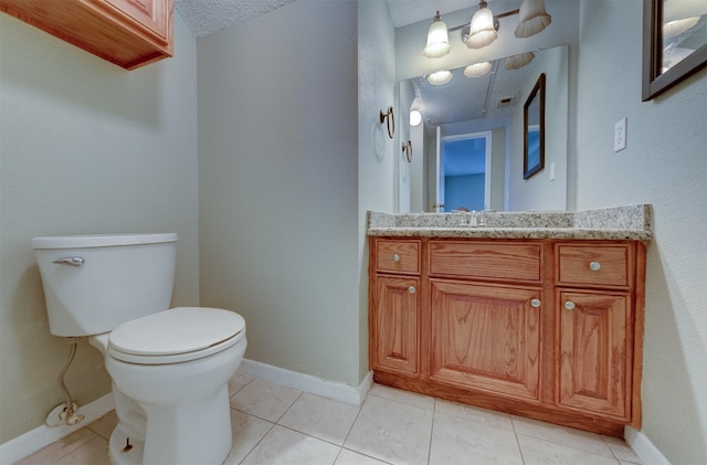 bathroom featuring tile patterned flooring, vanity, and toilet