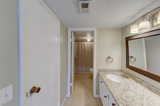 bathroom featuring vanity, a textured ceiling, curtained shower, tile patterned floors, and toilet