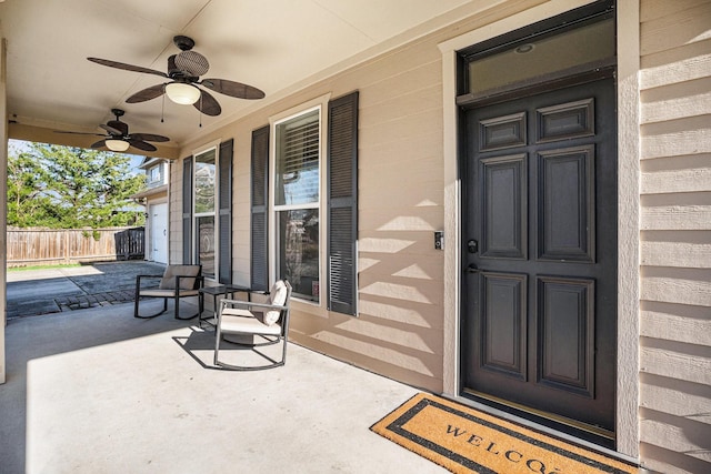 view of exterior entry featuring ceiling fan and covered porch