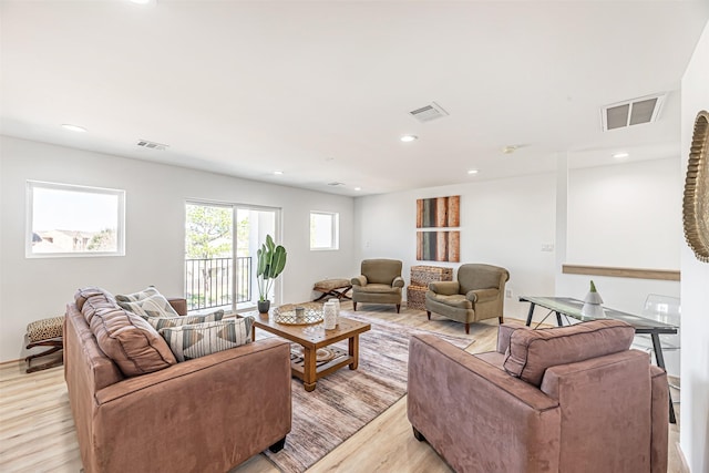 living room featuring light wood-type flooring, visible vents, and recessed lighting