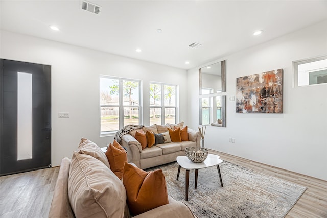 living room featuring light wood finished floors, visible vents, and recessed lighting