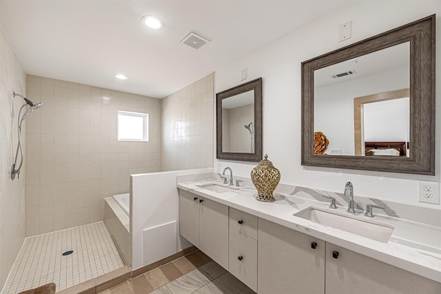 full bath with visible vents, a tile shower, and a sink