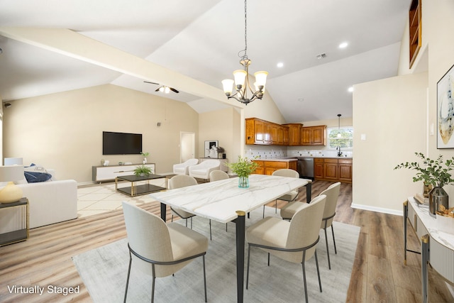 dining room with lofted ceiling, sink, light hardwood / wood-style floors, and an inviting chandelier