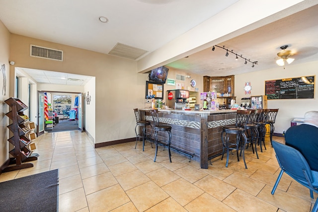 bar featuring ceiling fan, track lighting, and light tile patterned floors