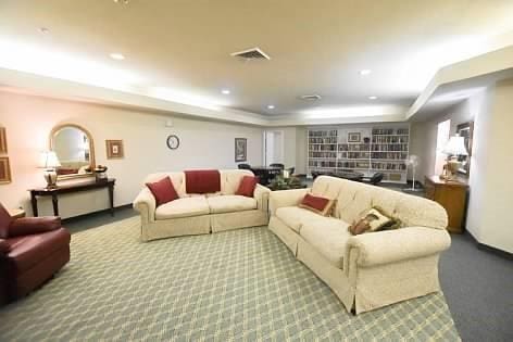 living room with a tray ceiling and carpet floors